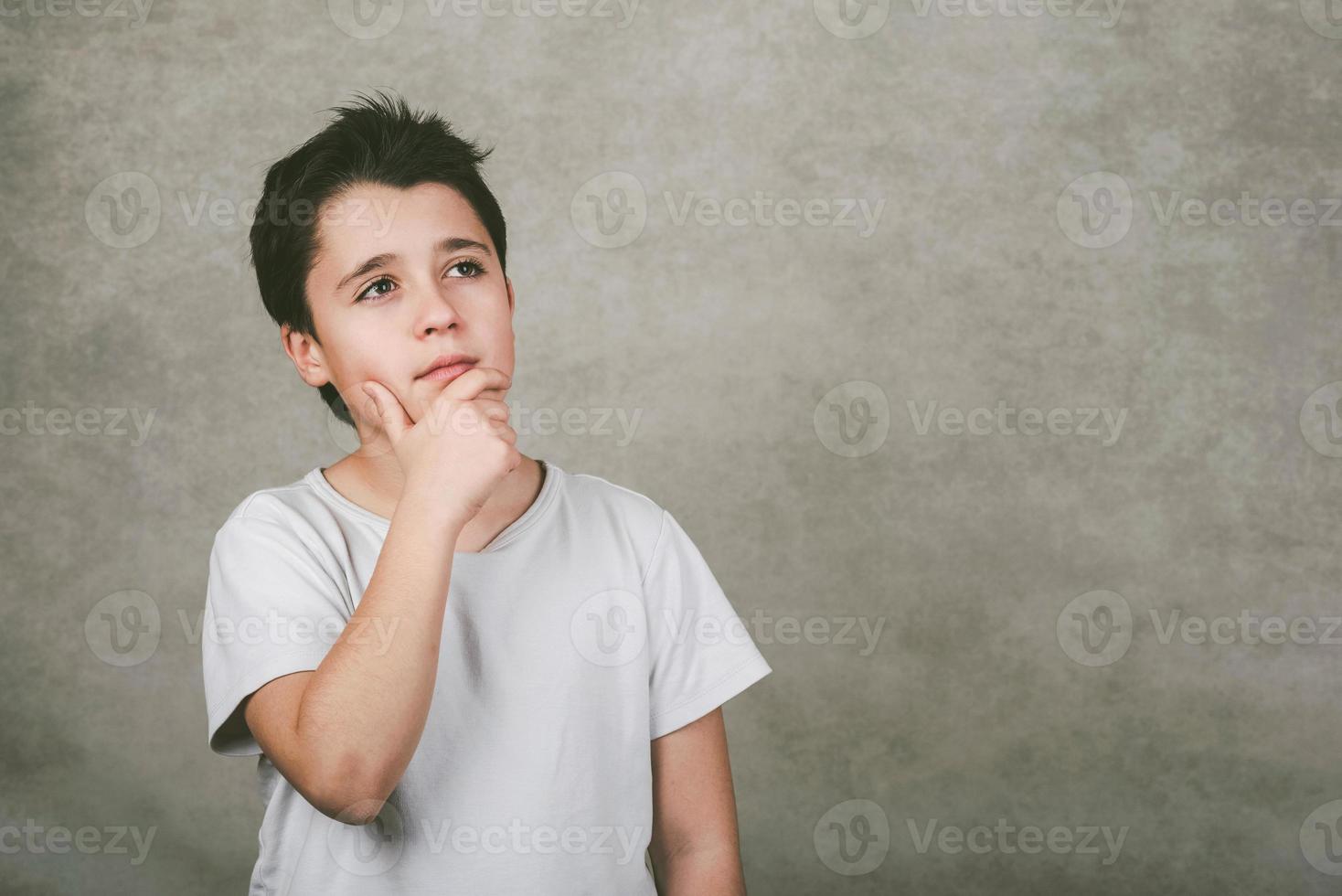 thoughtful kid over gray background photo