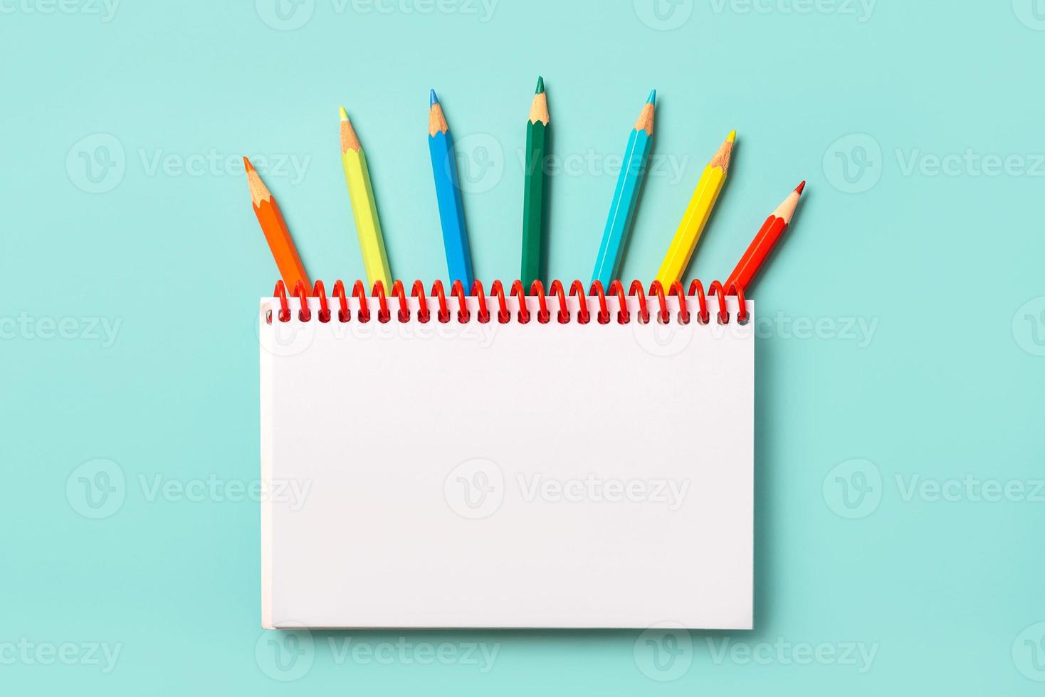 cuaderno espiral con lápices de colores y con espacio de copia para su imagen o texto foto