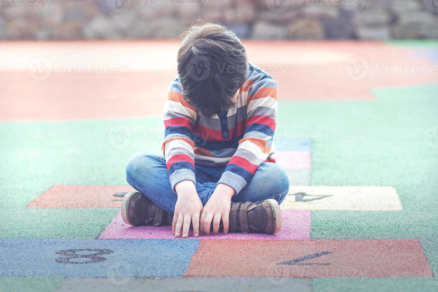 Sad boy sitting on the floor photo