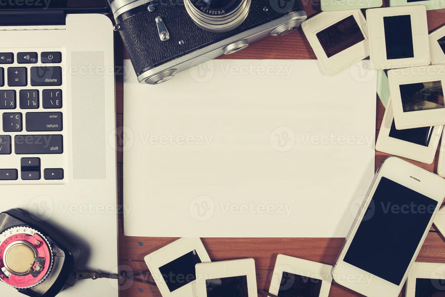 retro camera and some old photos on wooden table.