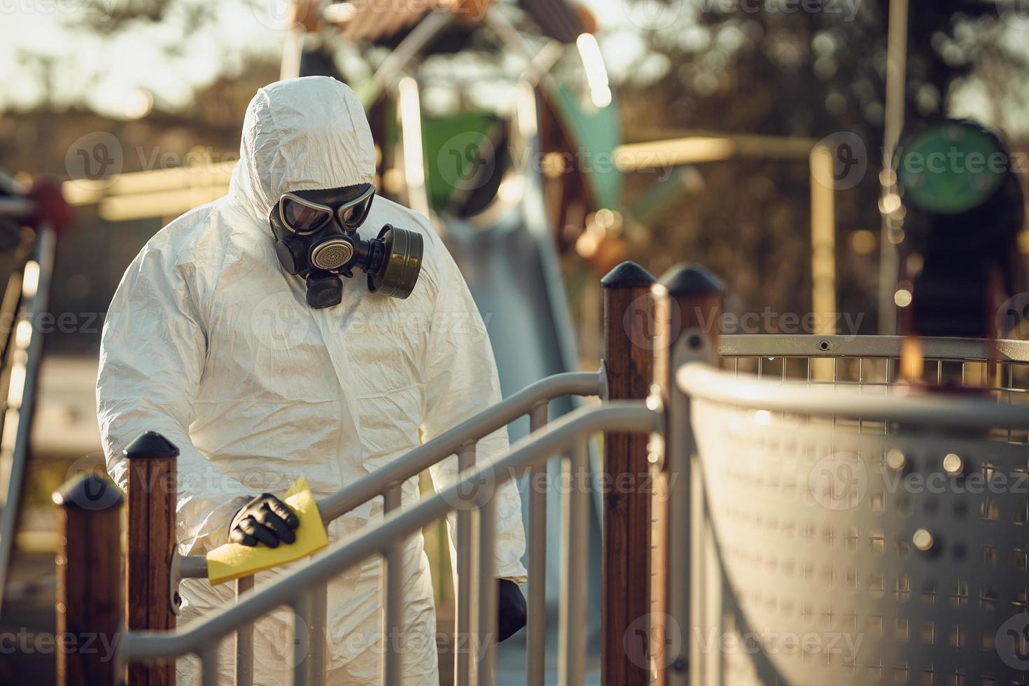 Cleaning and Disinfection on the playground in the sity complex amid the coronavirus epidemic Teams for disinfection efforts Infection prevention and control of epidemic Protective suit and mask photo