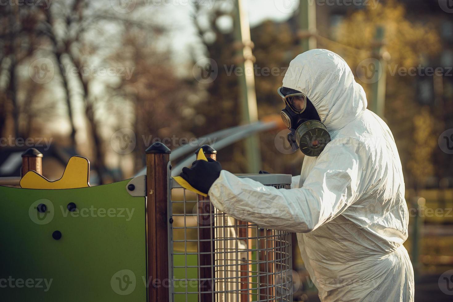 Cleaning and Disinfection on the playground in the sity complex amid the coronavirus epidemic Teams for disinfection efforts Infection prevention and control of epidemic Protective suit and mask photo