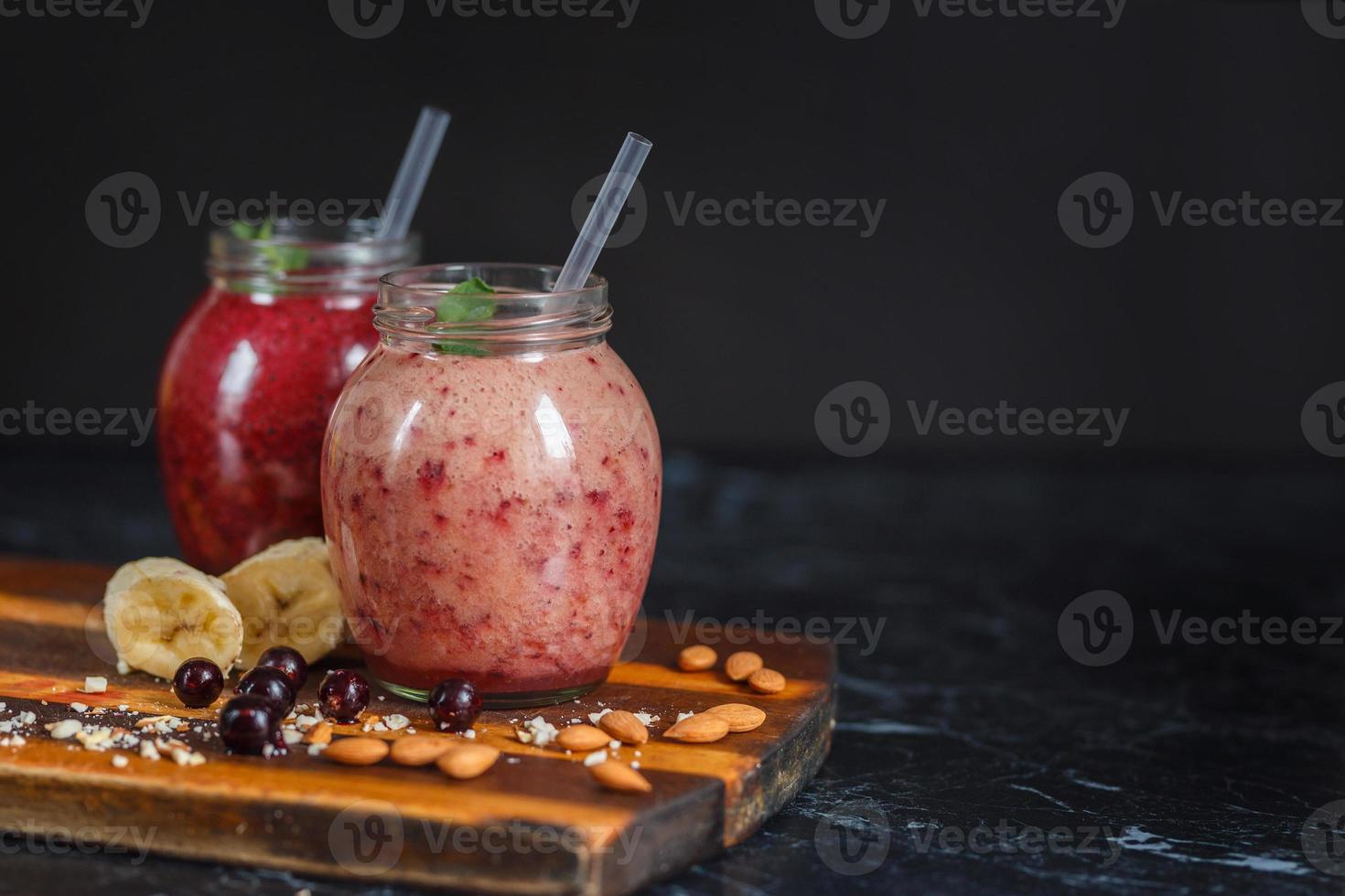 batidos recién preparados de plátano con granada y plátano con mora en botella. dieta, estilo de vida saludable foto