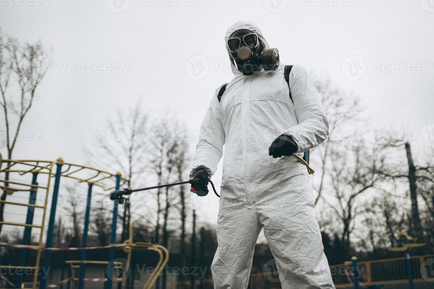 Cleaning and Disinfection on the playground in the sity complex amid the coronavirus epidemic Teams for disinfection efforts Infection prevention and control of epidemic Protective suit and mask photo