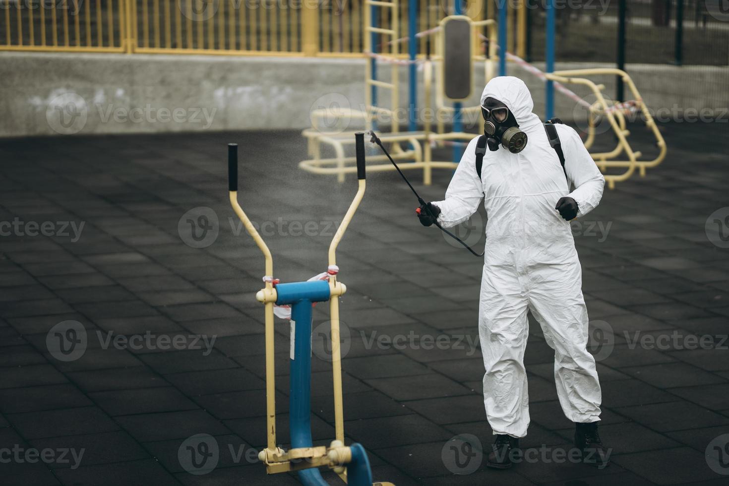 Cleaning and Disinfection on the playground in the sity complex amid the coronavirus epidemic Teams for disinfection efforts Infection prevention and control of epidemic Protective suit and mask photo