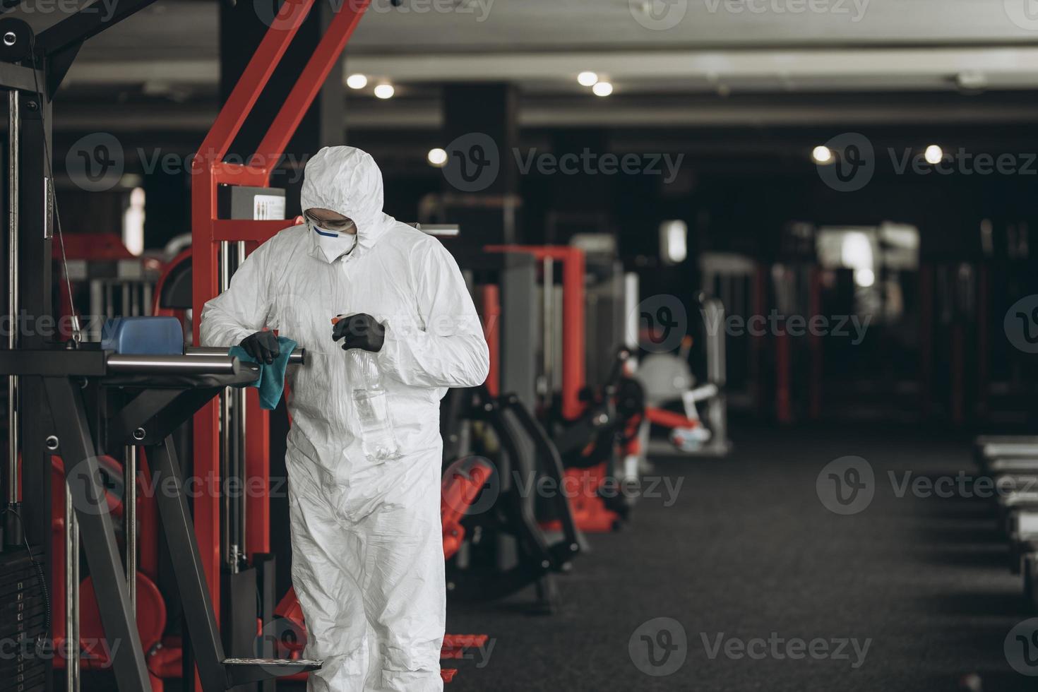 Cleaning and Disinfection in crowded places amid the coronavirus epidemic Gym cleaning and disinfection Infection prevention and control of epidemic. Protective suit and mask and spray bag photo