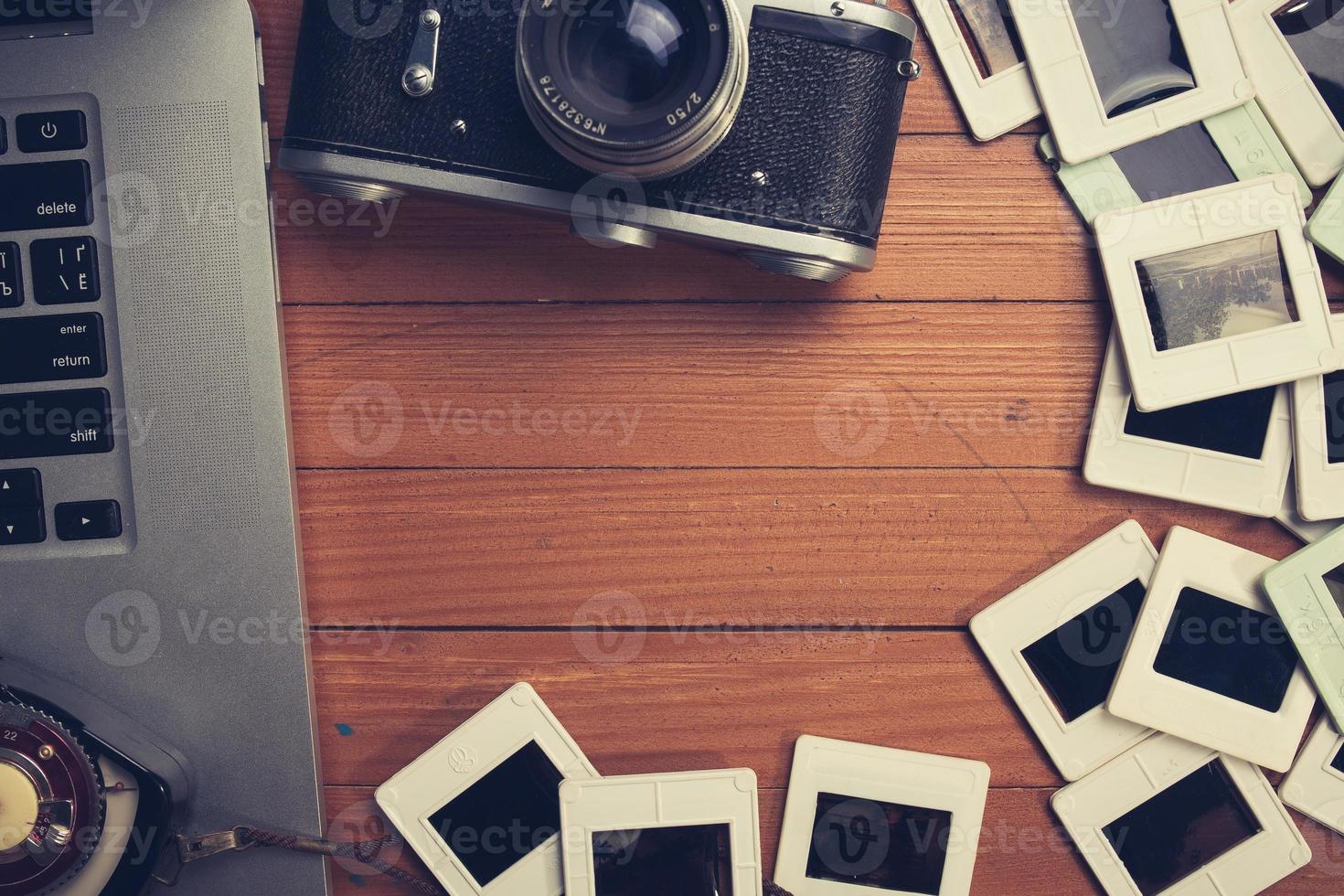 composition of old photo camera, laptop and slides