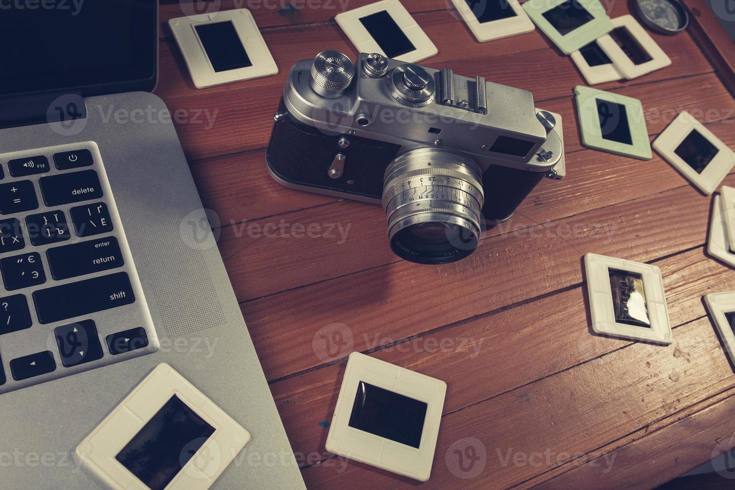 composition of old photo camera, laptop and slides