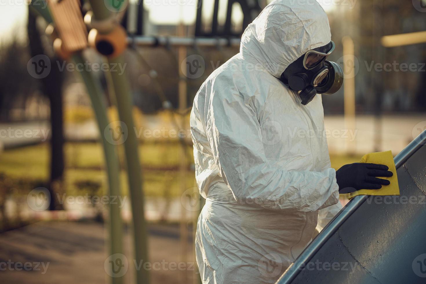 Cleaning and Disinfection on the playground in the sity complex amid the coronavirus epidemic Teams for disinfection efforts Infection prevention and control of epidemic Protective suit and mask photo