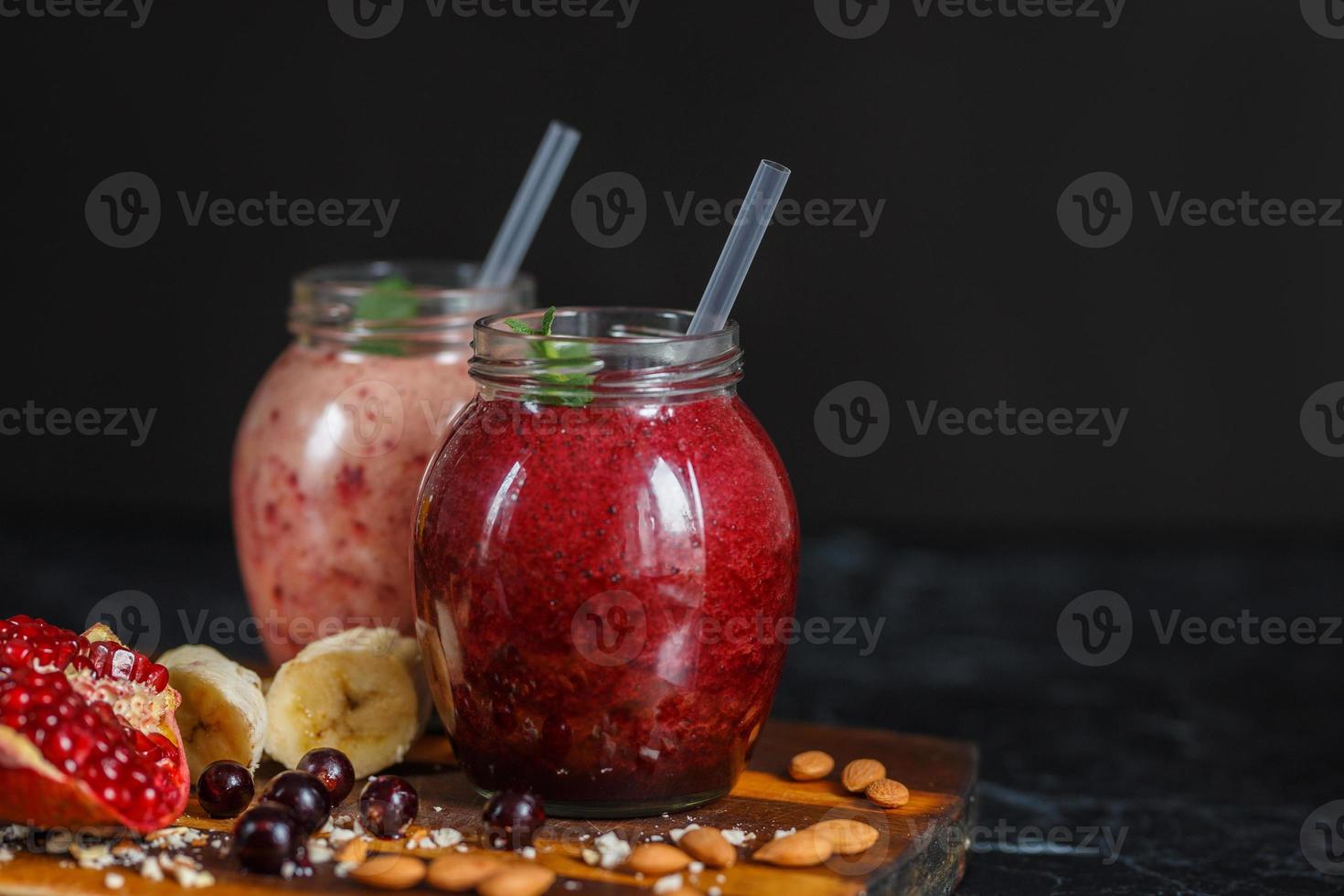 batidos recién preparados de plátano con granada y plátano con mora en botella. dieta, estilo de vida saludable foto