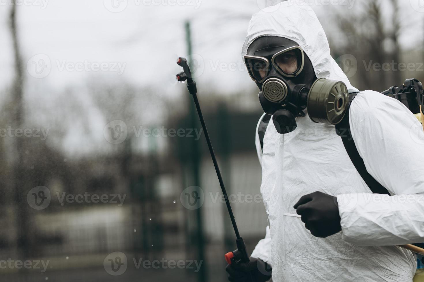 limpieza y desinfección en el complejo de la ciudad en medio de la epidemia de coronavirus equipos profesionales para los esfuerzos de desinfección prevención y control de infecciones de traje y máscara de protección epidémica foto