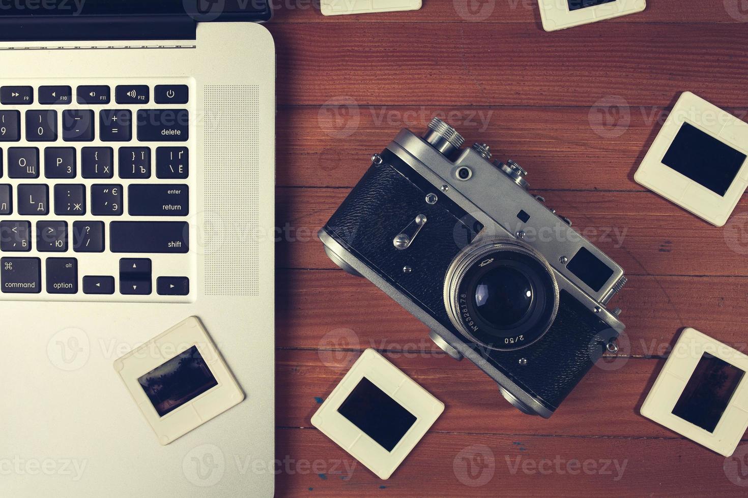 composition of old photo camera, laptop and slides