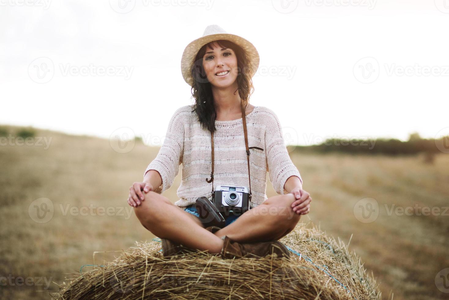 Smiling girl sitting on the straw photo