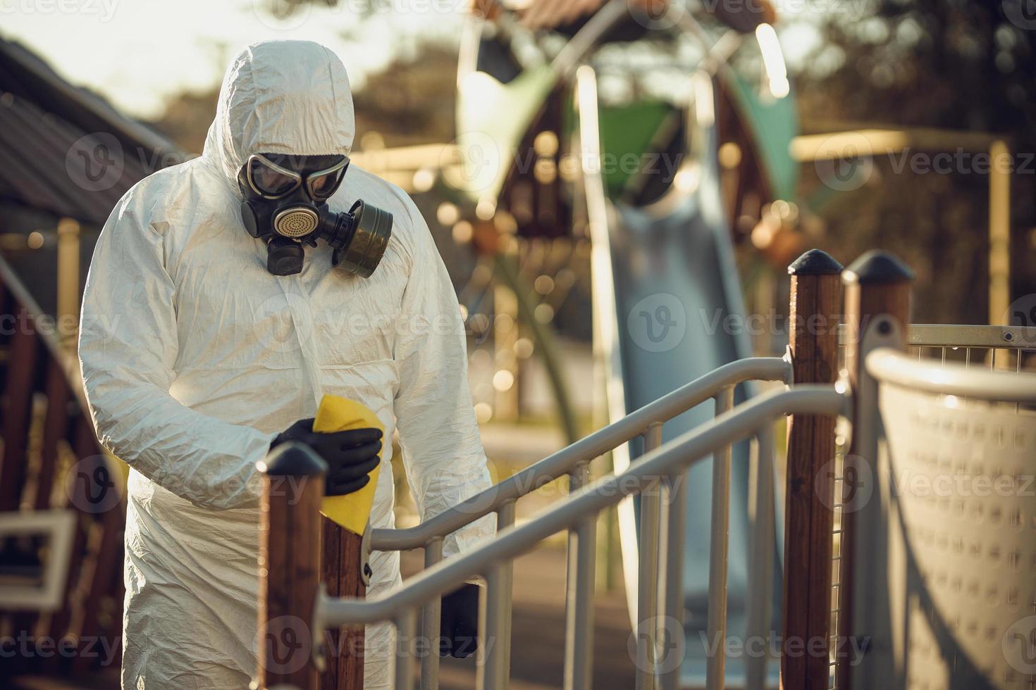 Cleaning and Disinfection on the playground in the sity complex amid the coronavirus epidemic Teams for disinfection efforts Infection prevention and control of epidemic Protective suit and mask photo