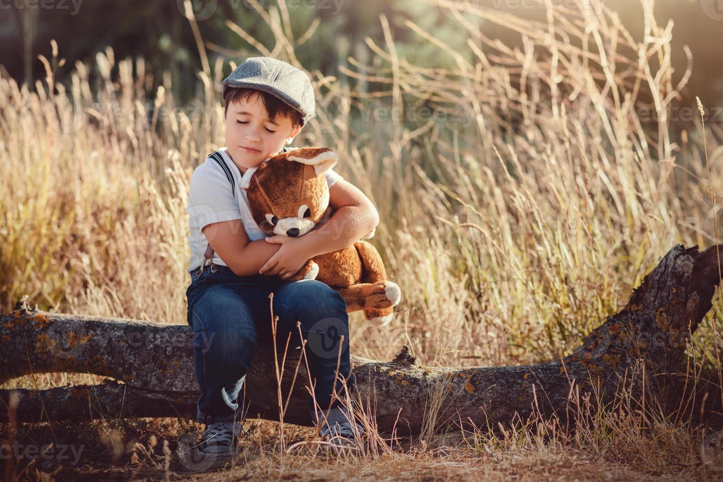 Boy hugging his teddy bear photo