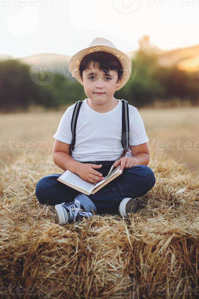 niño leyendo un libro en el campo foto