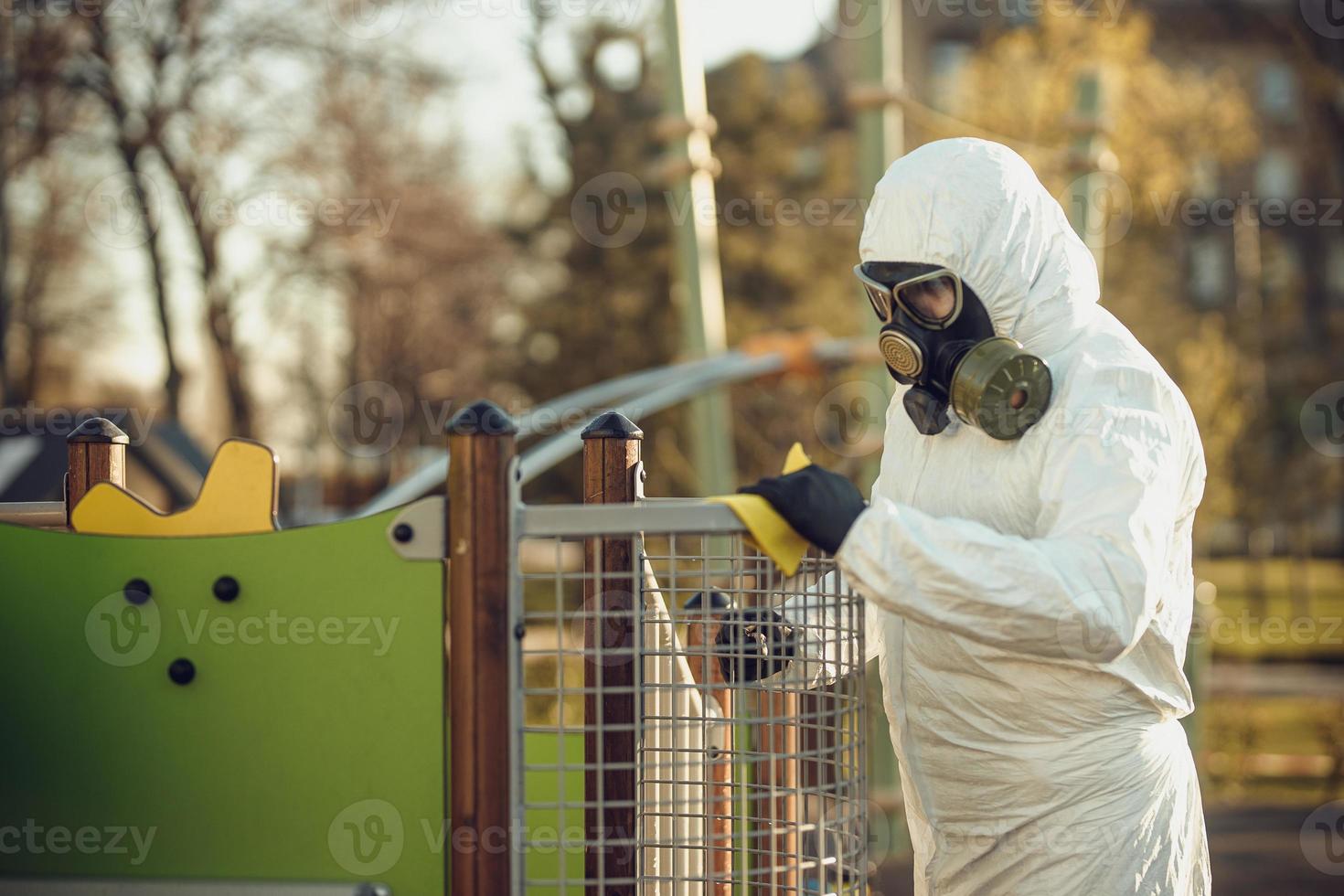 Cleaning and Disinfection on the playground in the sity complex amid the coronavirus epidemic Teams for disinfection efforts Infection prevention and control of epidemic Protective suit and mask photo