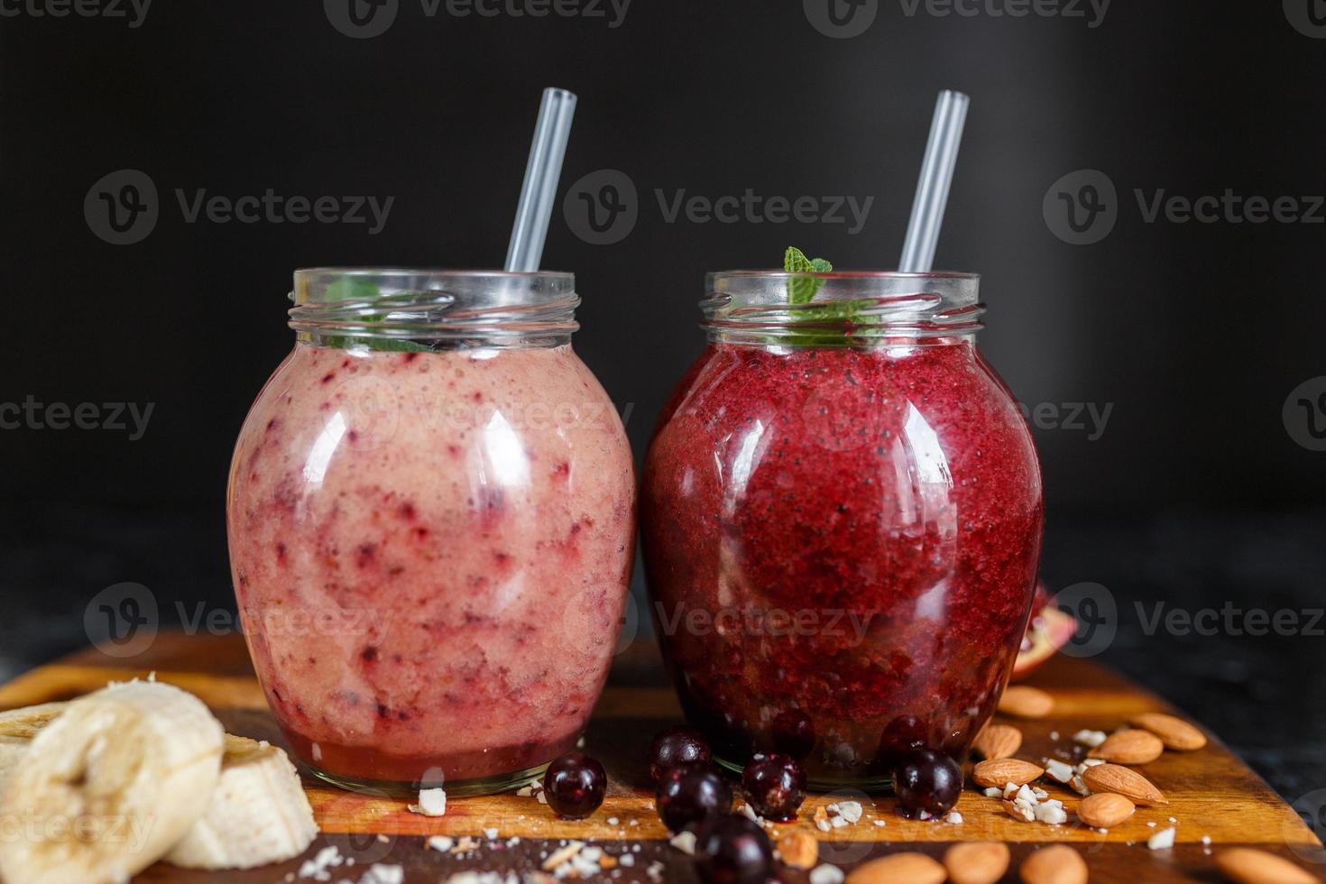 batidos recién preparados de plátano con granada y plátano con mora en botella. dieta, estilo de vida saludable foto