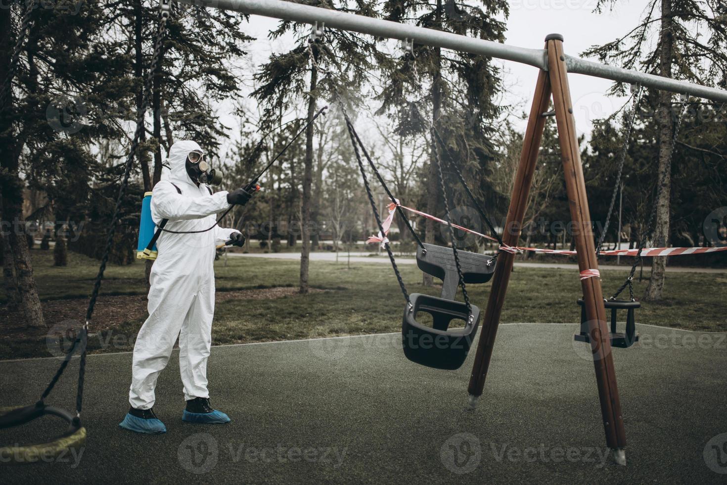 Cleaning and Disinfection on the playground in the sity complex amid the coronavirus epidemic Teams for disinfection efforts Infection prevention and control of epidemic Protective suit and mask photo