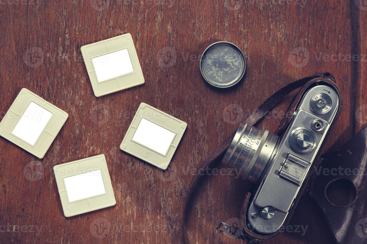 retro camera and old slides lay on a chair photo