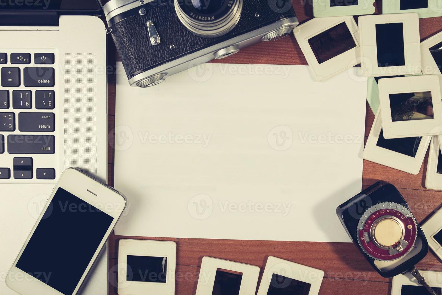 retro camera and some old photos on wooden table.