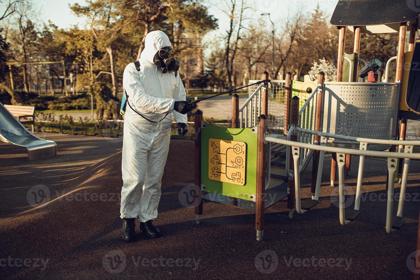 Cleaning and Disinfection on the playground in the sity complex amid the coronavirus epidemic Teams for disinfection efforts Infection prevention and control of epidemic Protective suit and mask photo