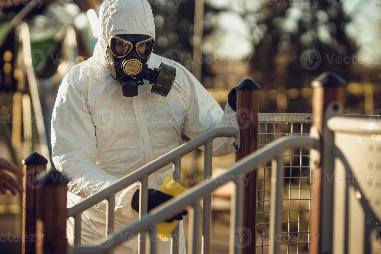 Cleaning and Disinfection on the playground in the sity complex amid the coronavirus epidemic Teams for disinfection efforts Infection prevention and control of epidemic Protective suit and mask photo