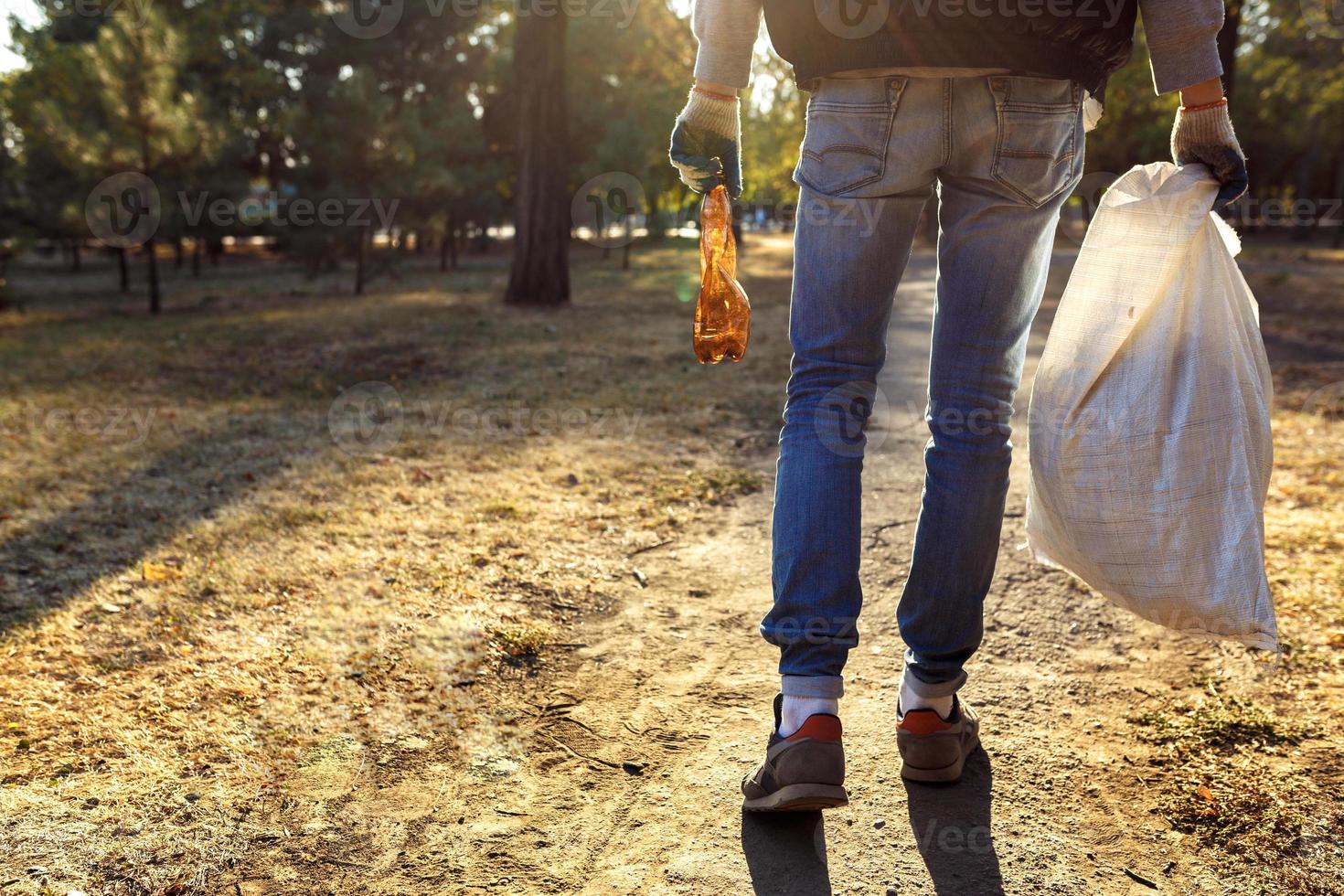 young man picking up trash photo