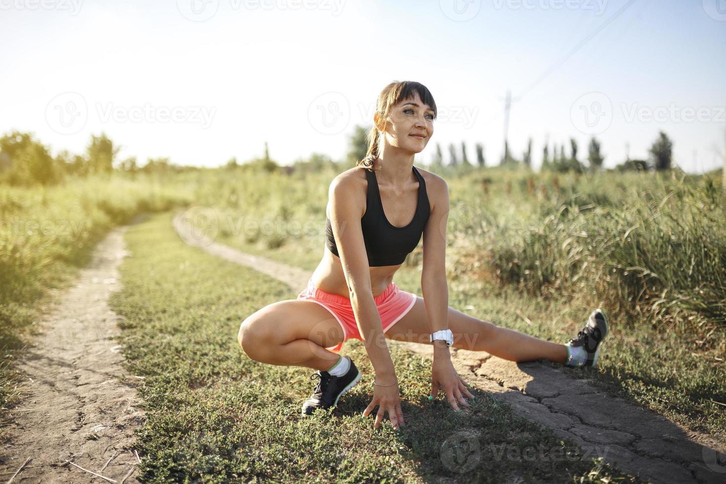 joven deportista estirándose y preparándose para correr. foto