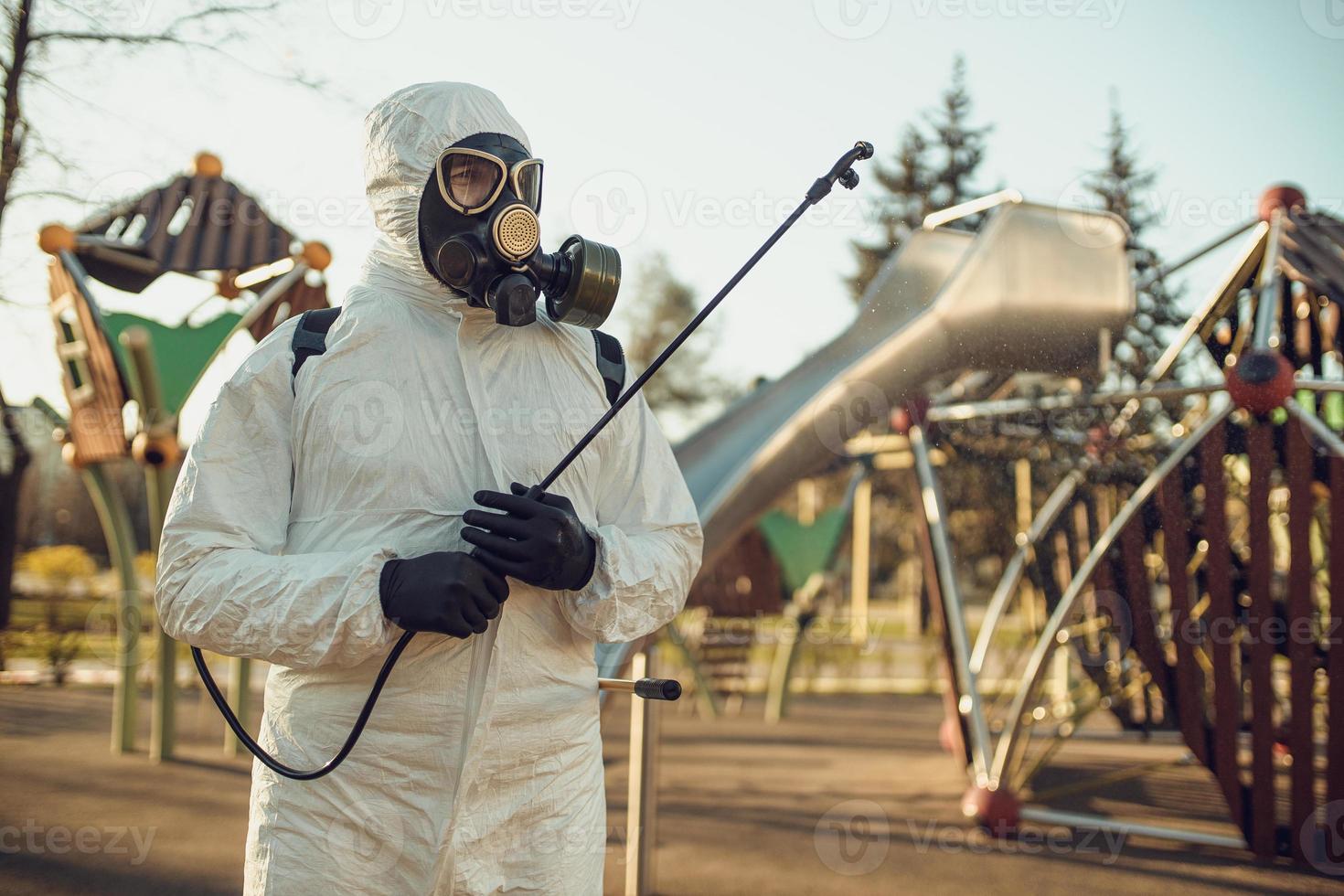 Cleaning and Disinfection on the playground in the sity complex amid the coronavirus epidemic Teams for disinfection efforts Infection prevention and control of epidemic Protective suit and mask photo