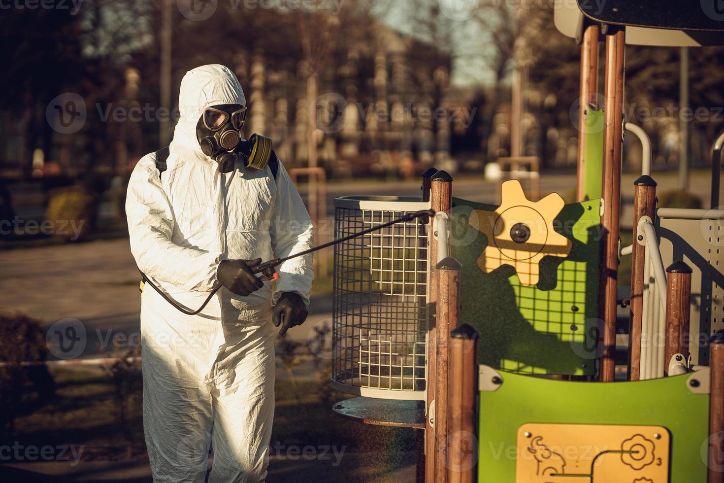 Cleaning and Disinfection on the playground in the sity complex amid the coronavirus epidemic Teams for disinfection efforts Infection prevention and control of epidemic Protective suit and mask photo