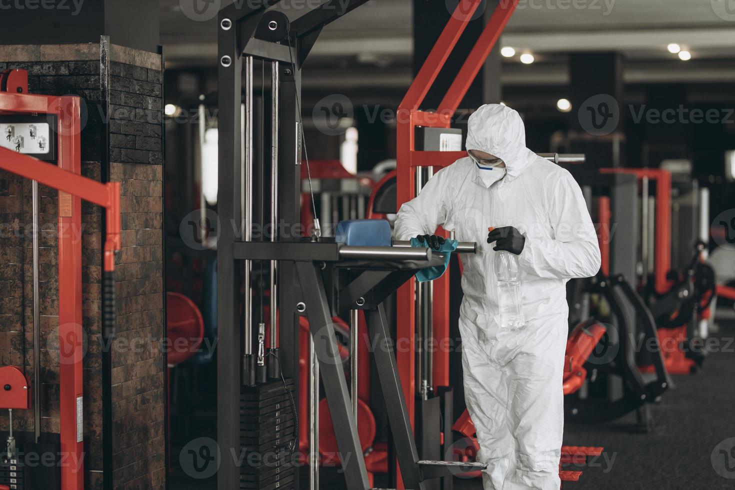 Cleaning and Disinfection in crowded places amid the coronavirus epidemic Gym cleaning and disinfection Infection prevention and control of epidemic. Protective suit and mask and spray bag photo