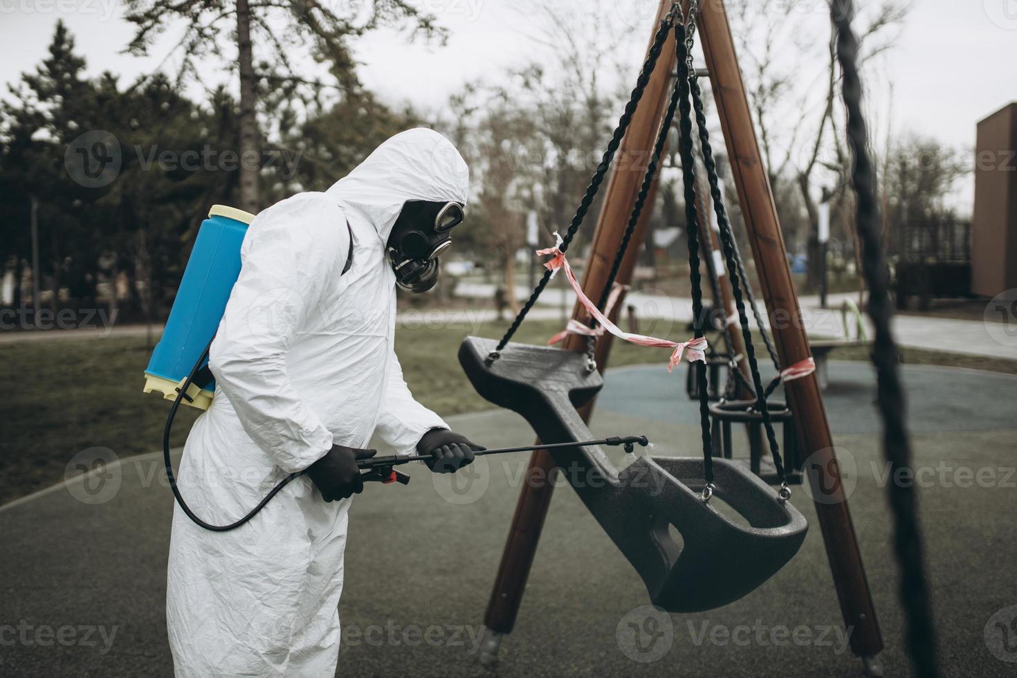 Cleaning and Disinfection on the playground in the sity complex amid the coronavirus epidemic Teams for disinfection efforts Infection prevention and control of epidemic Protective suit and mask photo