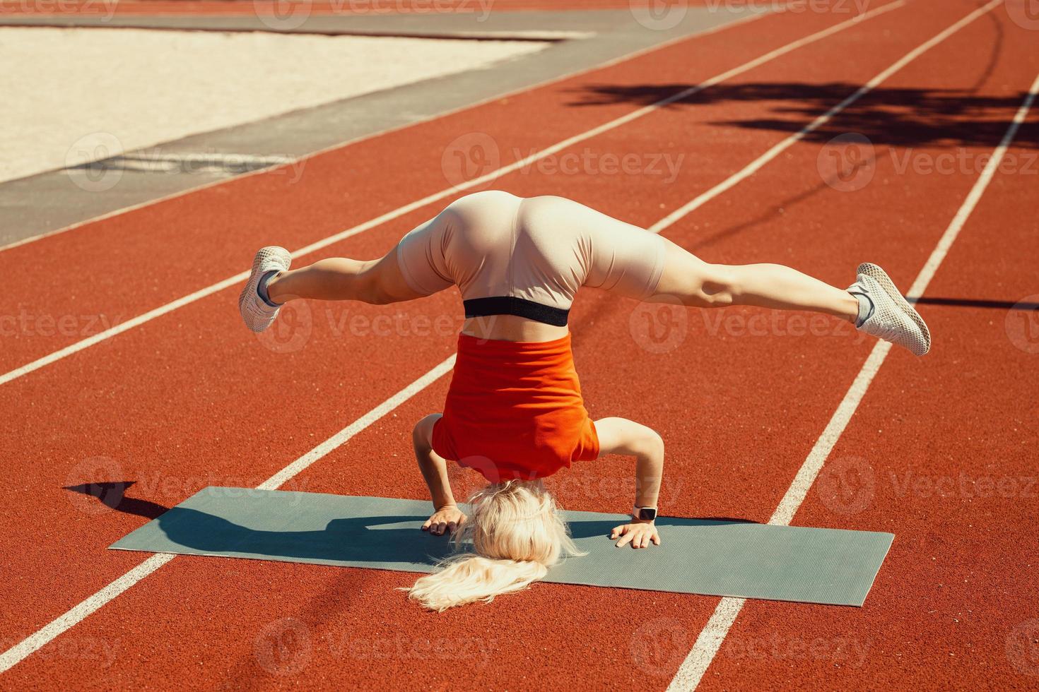 young blonde learns to balance in a headstand and handstand photo
