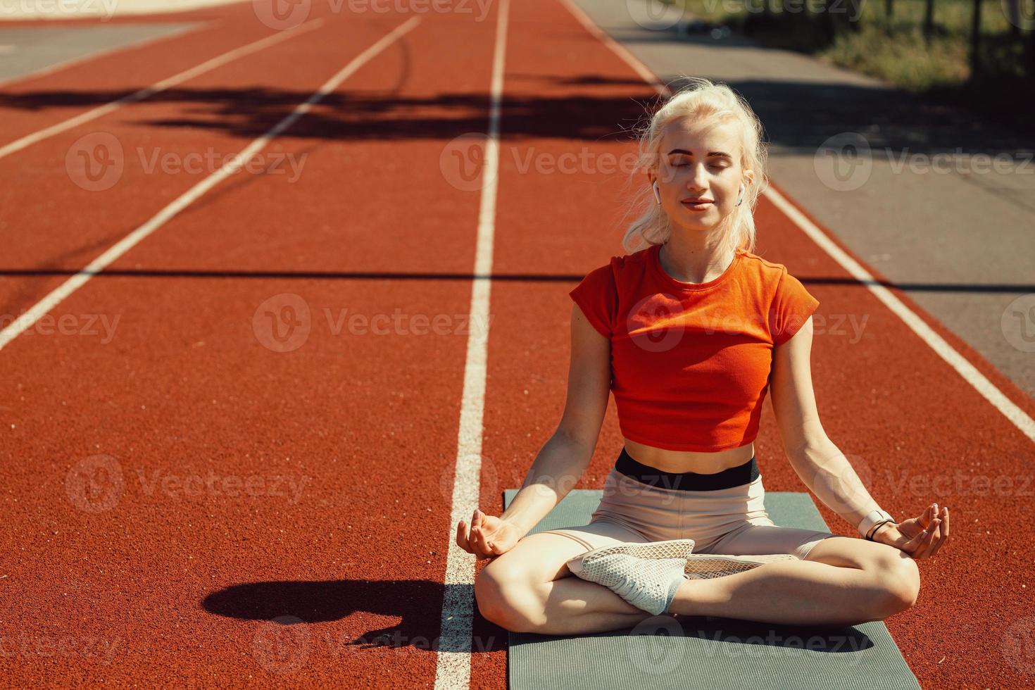 joven rubia se relaja en una alfombra deportiva foto