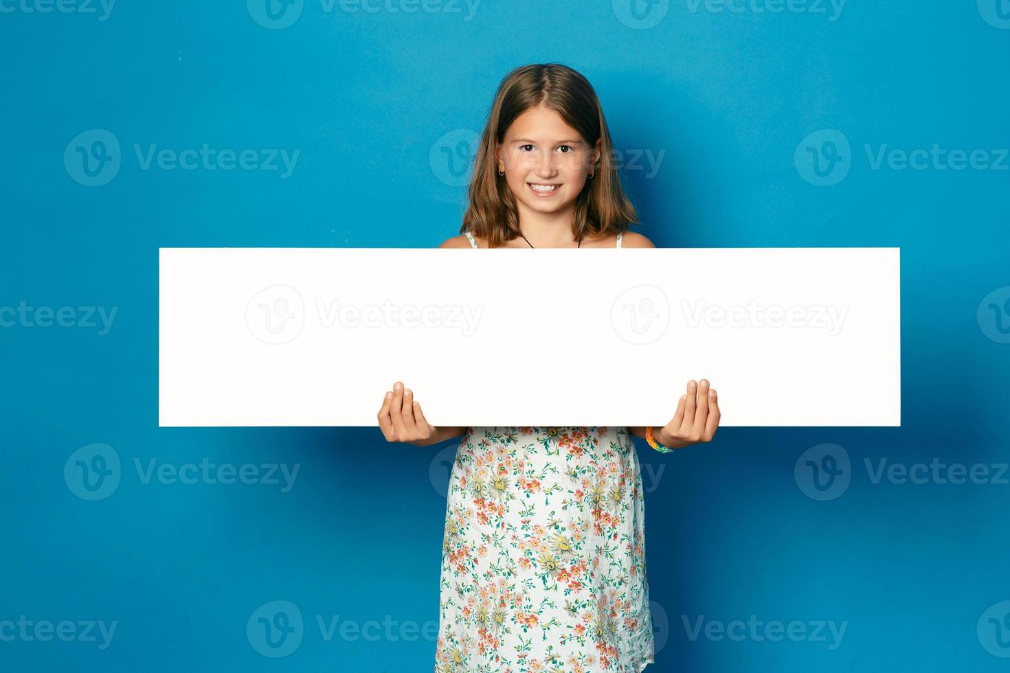 beautiful smiling girl with white teeth holding in hands white blank copy space for the announcement photo