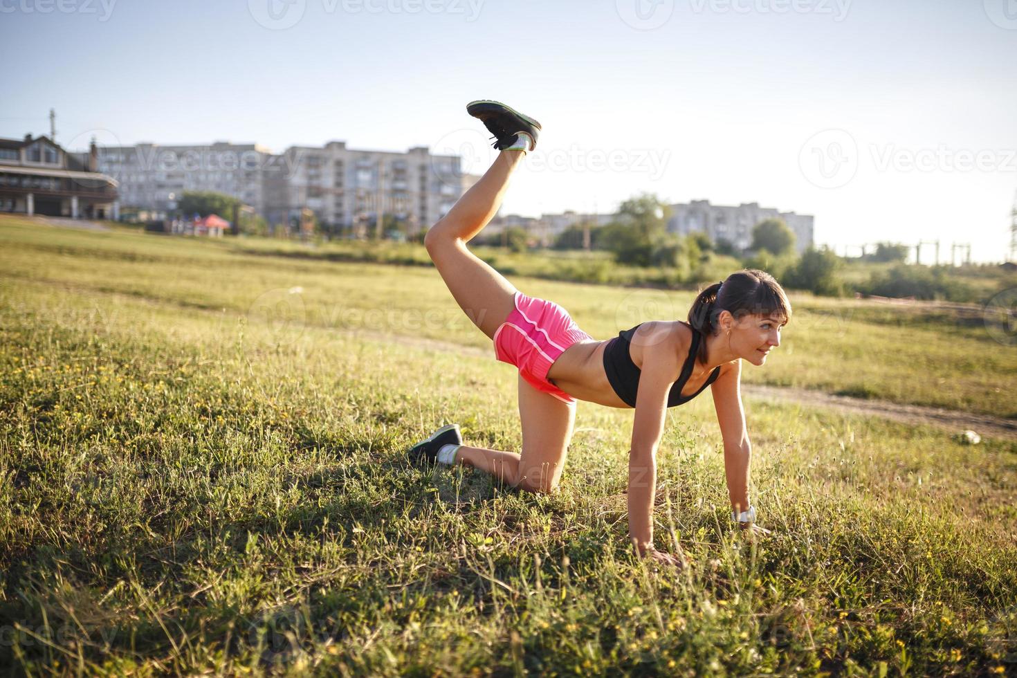 Young sports woman stretching and preparing to run. photo