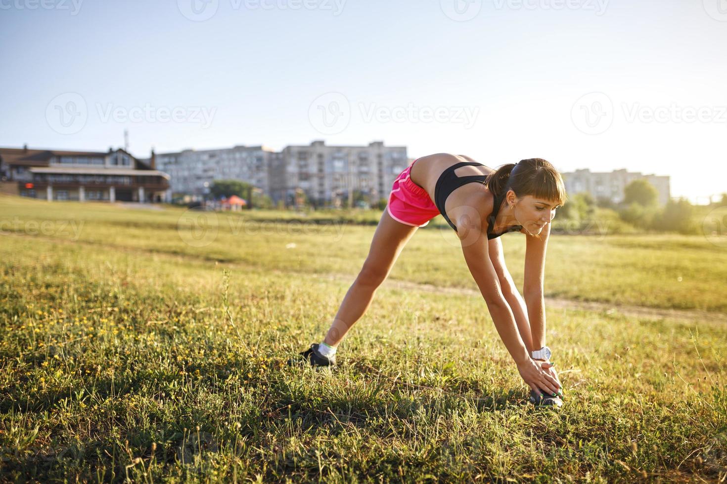 joven deportista estirándose y preparándose para correr. foto