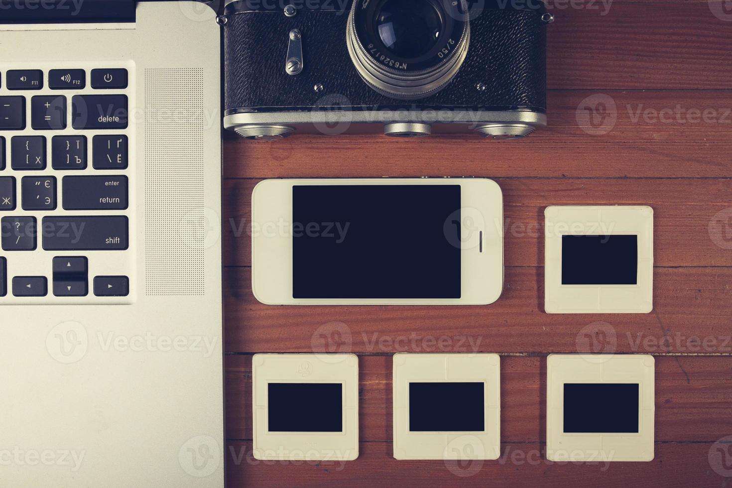 retro camera and some old photos on wooden table.