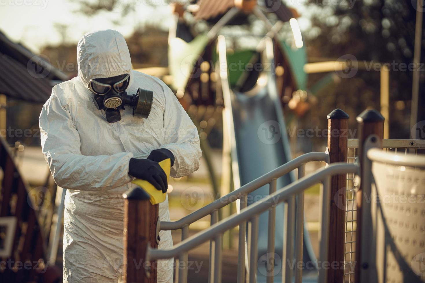 Cleaning and Disinfection on the playground in the sity complex amid the coronavirus epidemic Teams for disinfection efforts Infection prevention and control of epidemic Protective suit and mask photo