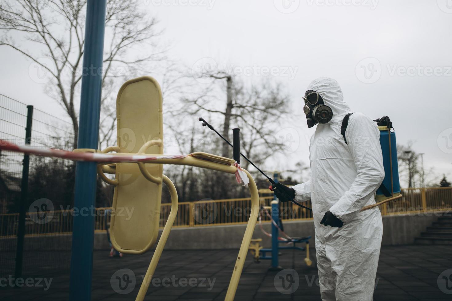 Cleaning and Disinfection on the playground in the sity complex amid the coronavirus epidemic Teams for disinfection efforts Infection prevention and control of epidemic Protective suit and mask photo
