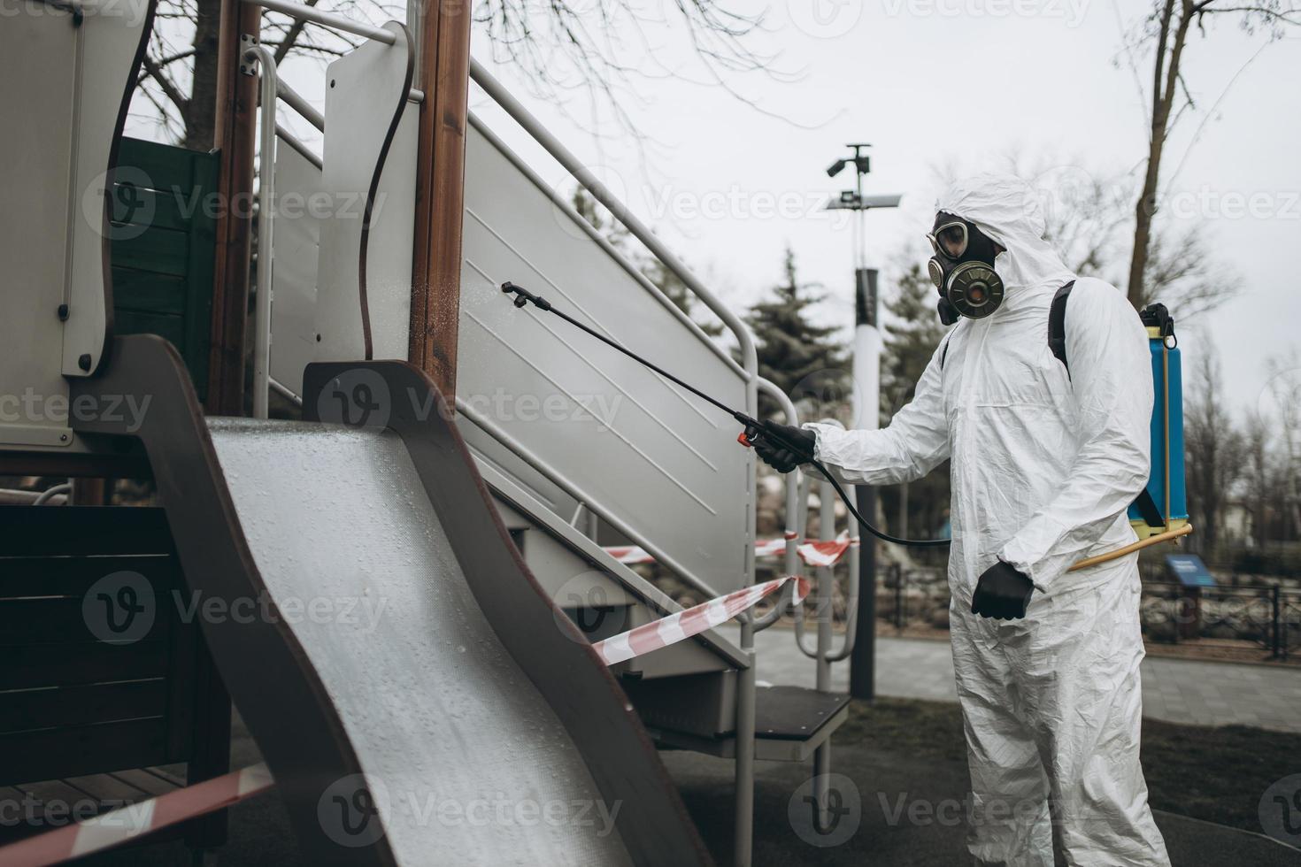 Cleaning and Disinfection on the playground in the sity complex amid the coronavirus epidemic Teams for disinfection efforts Infection prevention and control of epidemic Protective suit and mask photo