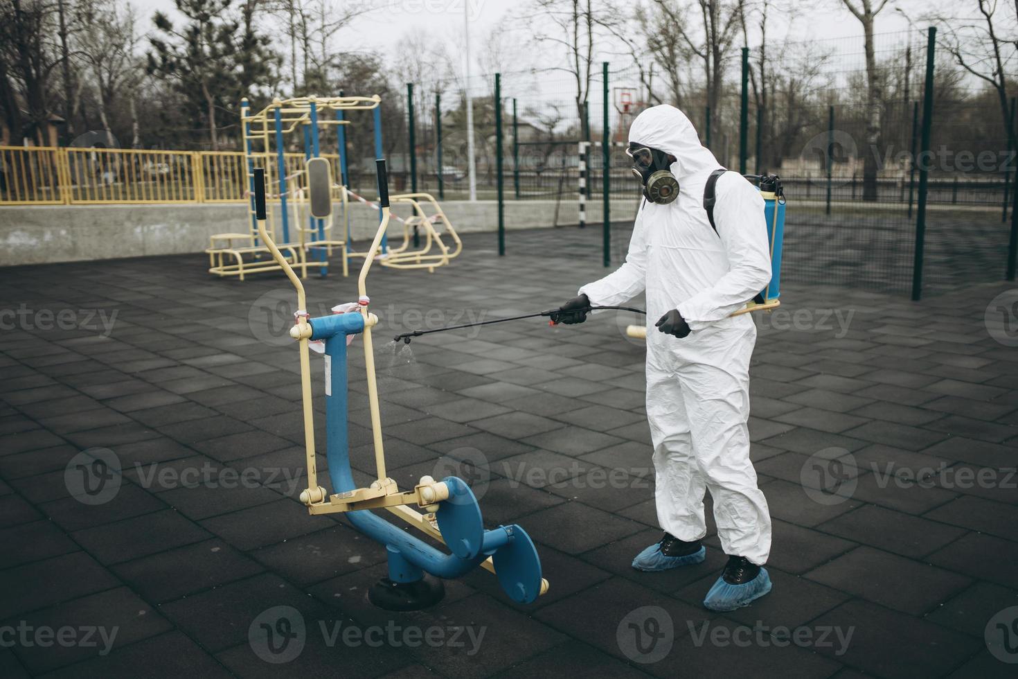 Cleaning and Disinfection on the playground in the sity complex amid the coronavirus epidemic Teams for disinfection efforts Infection prevention and control of epidemic Protective suit and mask photo