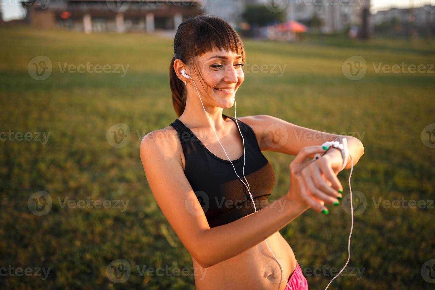 chica con pulsera de fitness en la muñeca al aire libre foto