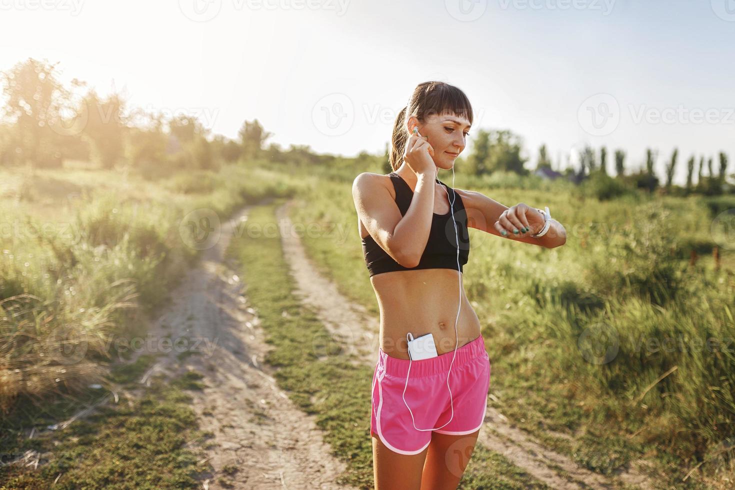 young girl goes in for sports with the gadget at hand photo