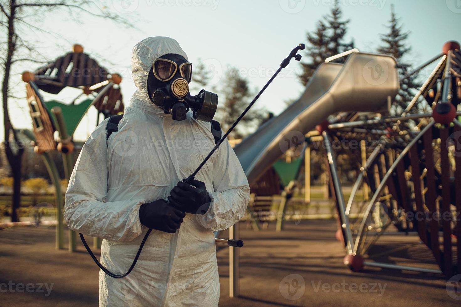 Cleaning and Disinfection on the playground in the sity complex amid the coronavirus epidemic Teams for disinfection efforts Infection prevention and control of epidemic Protective suit and mask photo