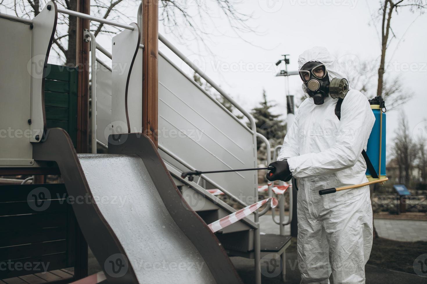 Cleaning and Disinfection on the playground in the sity complex amid the coronavirus epidemic Teams for disinfection efforts Infection prevention and control of epidemic Protective suit and mask photo