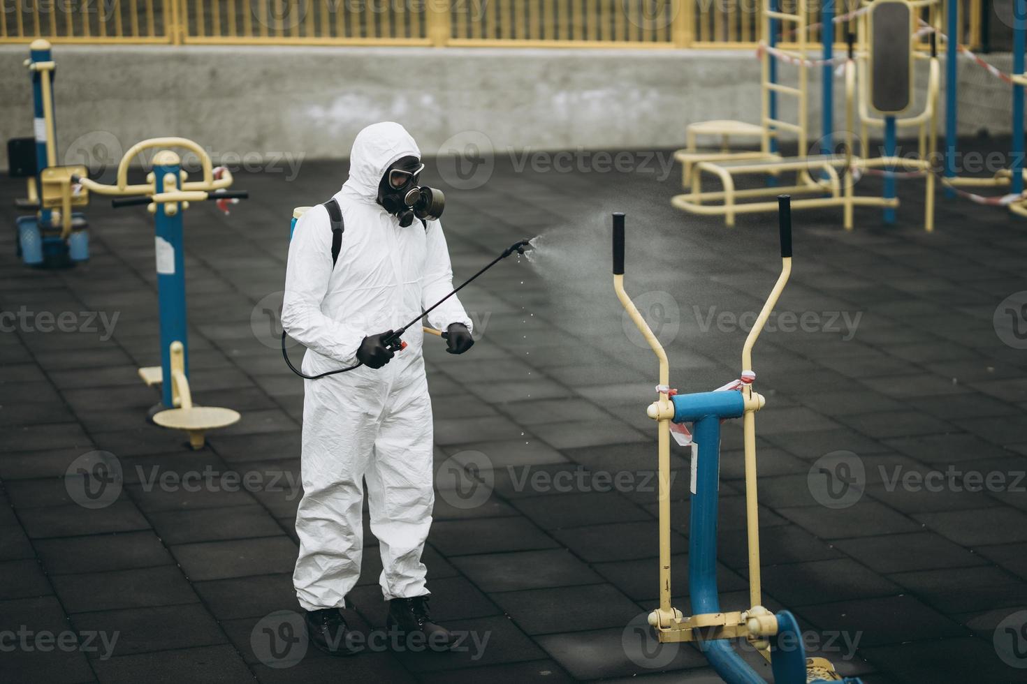 Cleaning and Disinfection on the playground in the sity complex amid the coronavirus epidemic Teams for disinfection efforts Infection prevention and control of epidemic Protective suit and mask photo