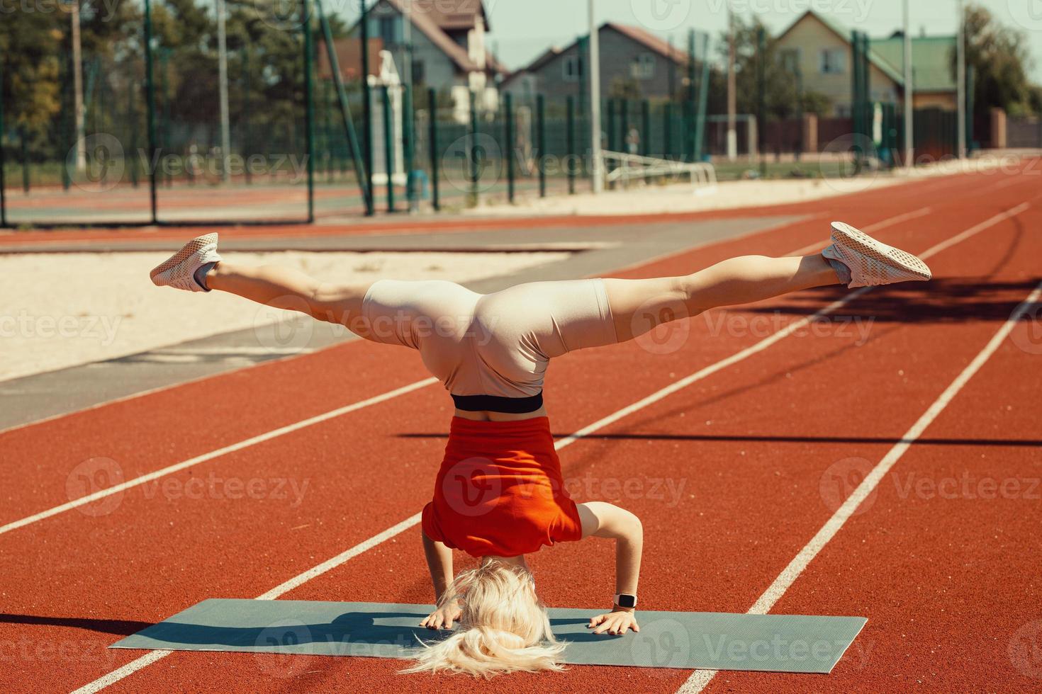 young blonde learns to balance in a headstand and handstand photo