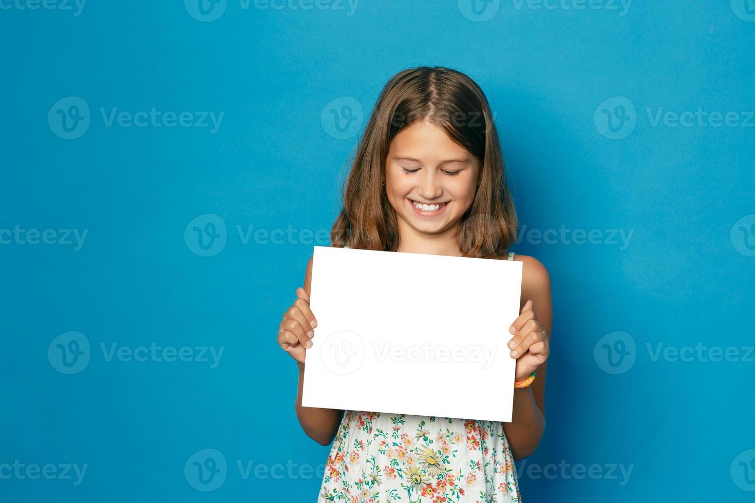 beautiful smiling girl with white teeth holding in hands white blank copy space for the announcement photo